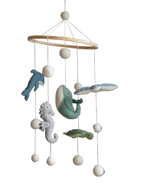 Decorative mobile with sea-themed hanging toys against a neutral background