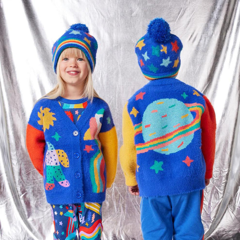 Two children wearing colorful outfits with space-themed designs against a silver curtain background.