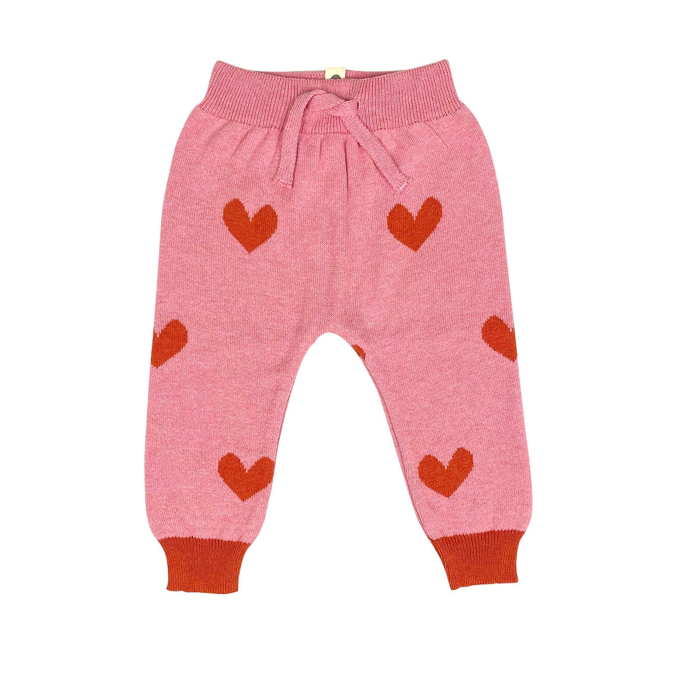 Pink children's pants with red heart patterns on a white background